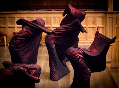 Five demons in their tight sheets bend in various configurations on the wood paneled stage