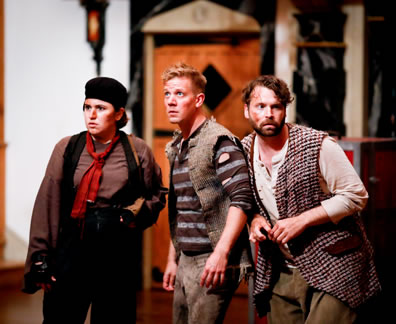 PRentis in brown shirt, black coveralls, red scarf tied around neck and black hat, Peter in holey blue and gray striped shirt, filthy pants and burlap fest, and Ted in grungy white shirt, checkered  rug as an oversized vest, green workpants look warily about.
