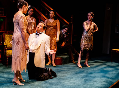 Production photo of Berowne, in white dinner, black bowtie and pants, kneeling before Rosaline.