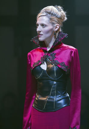 Elizabeth in red dress with black trim on high collar and black leather corset