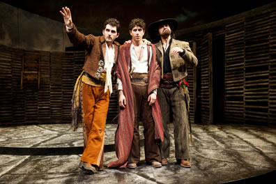 Dressed in rancho vaquero outfits, Benvolio and Mercutio flank a despondend Romeo.