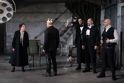 Production photo of the characters in black gothic clothes