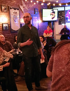 Photo of Minton presenting Sir Thomas More's speech in a bar full of patrons