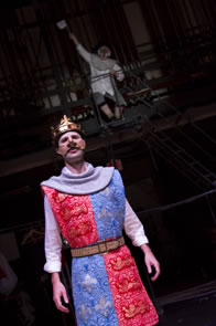 Production photo of Henry  with Harfleur Governor on ladder waving white flag high in the background