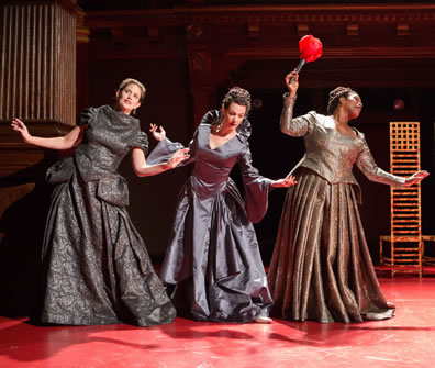 Francis-Kelly, Barbee, and Feamster (she's holding the large red flower) hold their hands out and tilt as if in a courtsy. 